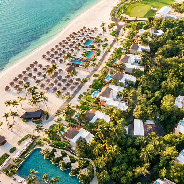 oceanfront beach club with infinity pools, rooftop bar and sun lounges lines sea at fairmont mayakoba